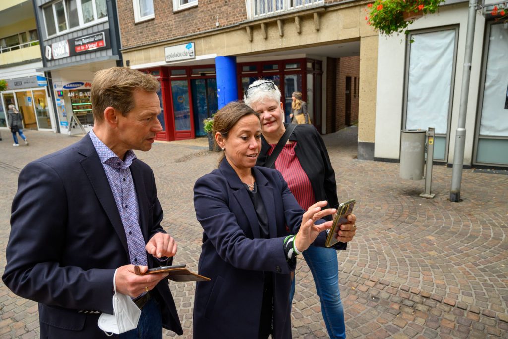 Thomas Waschki and Jule Wanders exploring AR sculptures by Vira DG at Osterplatz during Bocholt Open Spaces 2021. Verena Winter, the curator, is also present.